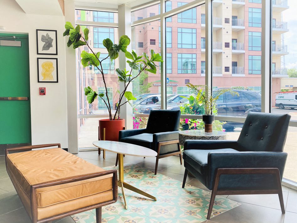 a living room with chairs and a table in front of a window